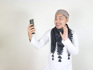 Fototapeta premium Handsome Asian Muslim man wearing black turban or shemagh showing dislike gesture by lowering thumbs down