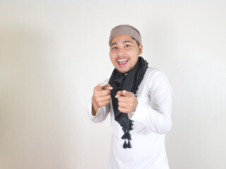 happy handsome asian muslim man wearing black turban or shemagh pointing forward