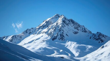 A snow-covered mountain peak under a clear blue sky.