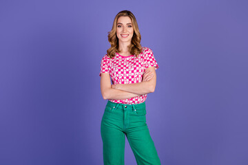 Stylish young woman posing confidently in colorful outfit against a purple background