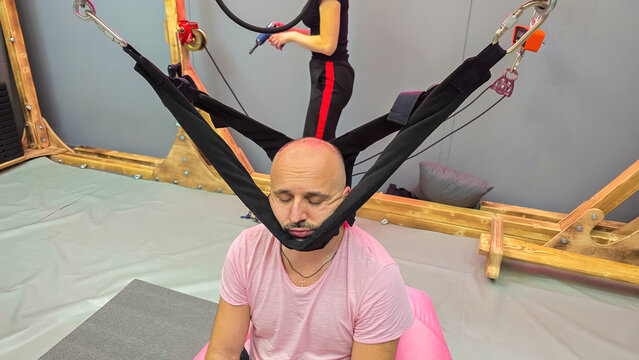 Patient relaxing during cervical traction therapy with innovative suspension system