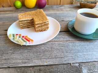 white coffee cup on an old wooden table next to a cake. High quality photos