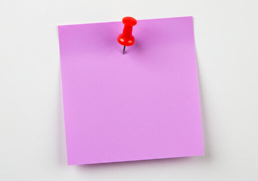 purple sticky post it note with red pushpin on white background