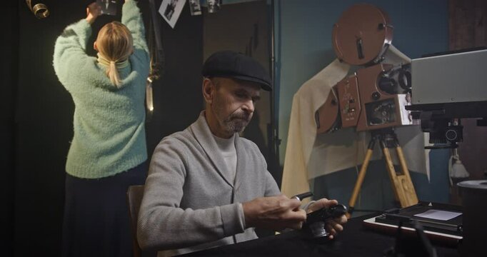 Elderly Couple Processing Vintage Film in Traditional Darkroom with Analog Photography Equipment