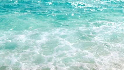 Obraz premium Clear turquoise ocean water with gentle waves and white foam at the shoreline. Concept Clear Turquoise Water, Gentle Ocean Waves, Shoreline Foam, Tropical Beach Scene, Serene Coastal Beauty