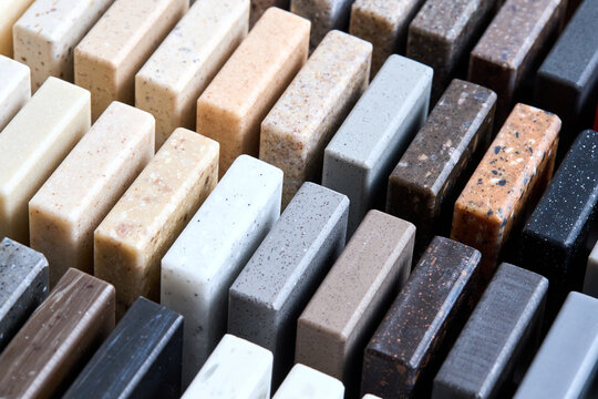 Porcelain stoneware artificial stone square samples as kitchen countertop examples of future kitchen fasade exterior. Samples slabs of natural granite marble quartz for stone countertops close up.