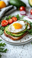 Delicious avocado toast topped with a fried egg, served with fresh tomatoes and arugula on a cozy kitchen table