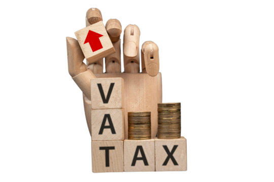 sztuczna dłoń układająca napisy dotyczące finansów: VAT, TAX, 