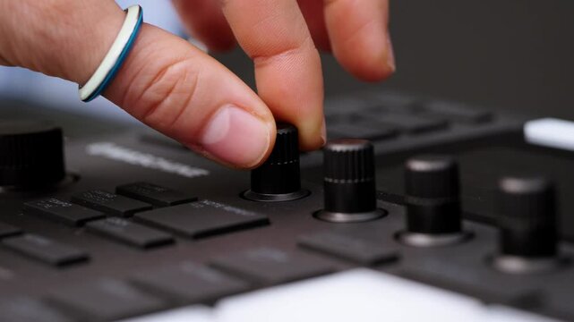 Music production technology controller, dial turning in a recording studio