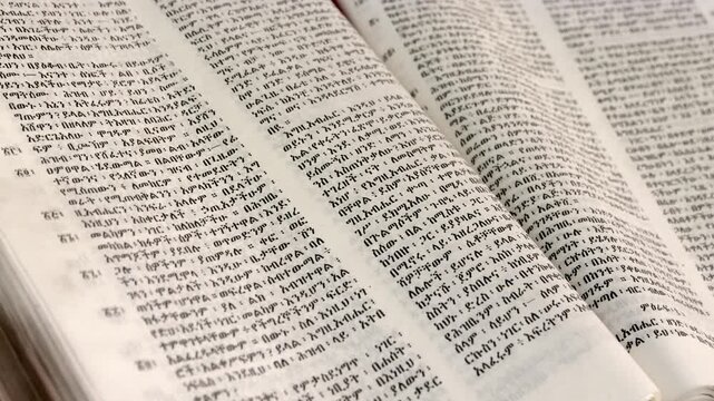 Close up slow panning shot of an open Ethiopian Amharic Bible
