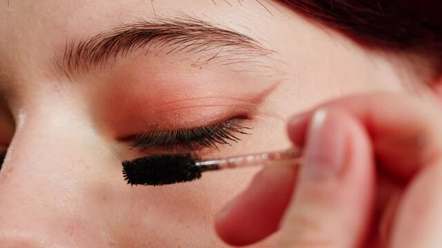 Eye shadow makeup to the upper eyeliner, close-up. Makeup artist applies a bright eye shadow with a makeup brush.Tutorial master class of professional makeup. 