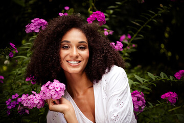 Photo of adorable cheerful girl dressed white stylish clothes enjoy blooming fresh flowers in...