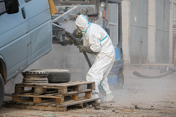 industrial processing of rusty metal of a car body with a sandblasting machine