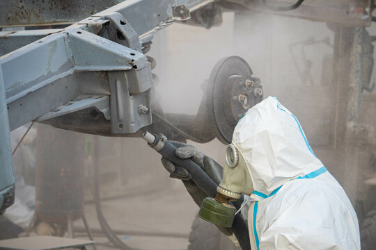 industrial processing of rusty metal of a car body with a sandblasting machine