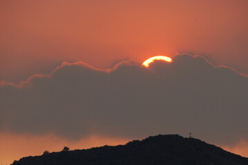 Small ray of sun, behind grey clouds