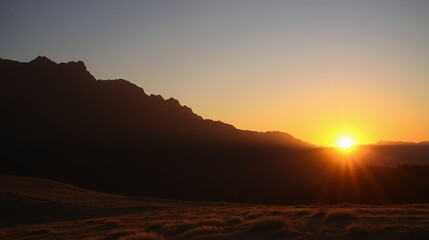 Obraz premium Breathtaking Sunrise Over Majestic Mountain Range with Silhouetted Peaks