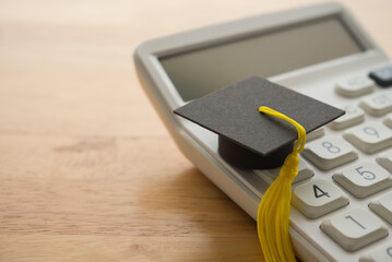 Mortarboard on calculator. Money financial management and planning for education, student debt or...