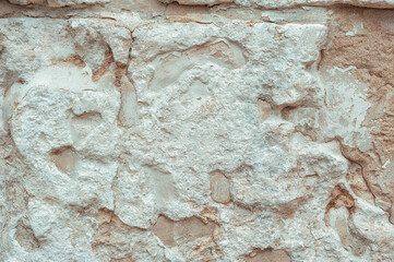 Weathered stone wall with rough texture and sandy tones