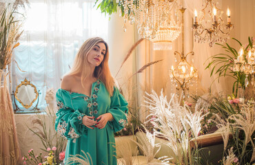 European Slavic woman posing in boho style turquoise dress. Concept of fashion. Hippie style and...