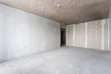 Obraz premium interior of the apartment without decoration in gray colors. rough finish