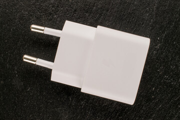 One power adapter for smartphone on slate stone, close-up.