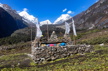 Resting place made by stone in stupa shape with beautiful mountain in the background.