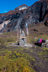 A high-altitude cultural landmark featuring a small stupa-like stone structure with religious inscriptions.