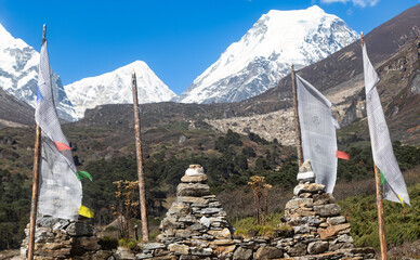 Snow mountain view with the stone stupa and white prayer flags.