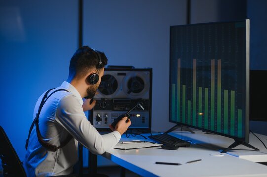 Secret agent listens on the reel tape recorder. Officer wiretapping in headphones