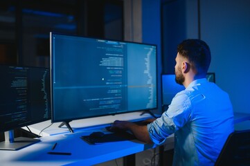 Portrait of male programmer in office at night