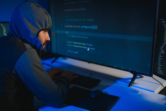 Hacker Using Multiple Computers For Stealing Data On Desk