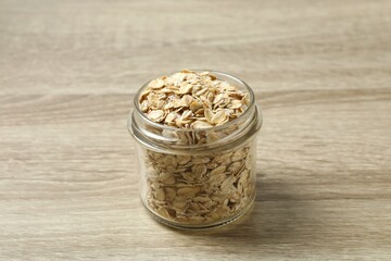 Composition with oatmeal flakes on wooden background. Cooking breakfast