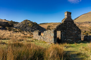 Derelict old stone built cottage from Victorian era slate industry in rural landscape