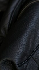 Fototapeta premium A detailed shot of a black leather jacket, highlighting the intricate stitching and textured grain.
