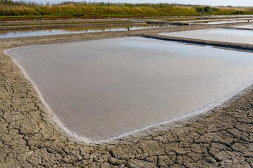 These salt evaporation ponds in the South of France showcase the art of salt harvesting. Sunlight...