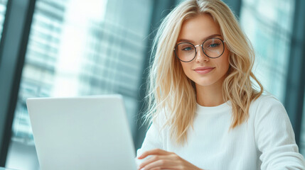 young woman with blonde hair and glasses is focused her laptop, exuding sense of concentration and engagement modern workspace