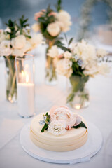 Wedding cake with floral decoration stands on a stand on the table