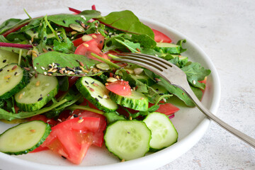 Fresh and healthy salad with cucumber, tomato and mixed green leaves