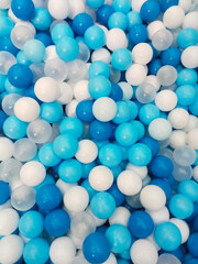 White and bright blue balls with a shiny and colorful pattern creates a textured background 