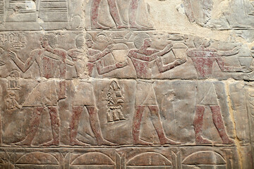 A colourful wall carving from the Ancient Egyptian mastaba of Mereruka in Saqqara showing men carrying offerings, Egypt