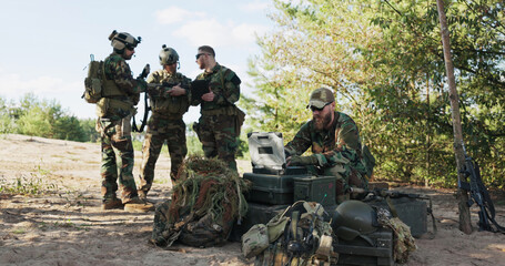 Soldiers prepare for deployment, finalizing mission details, securing equipment and clothing for a...