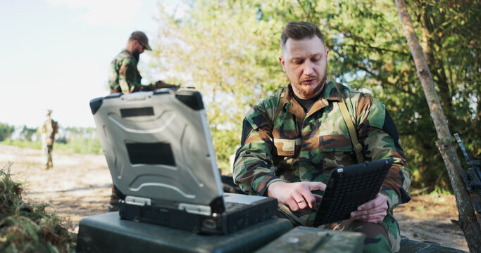 The experienced military commander, seated in the field, speaks via video call with the head of the army base, updating him on actions taken and security measures.