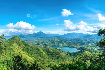 Obraz premium Panoramic View of Lush Mountains and a Serene Lake