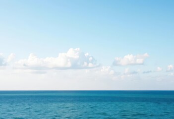 Obraz premium Soft, pale blue sky, scattered clouds above calm blue sea, bluesea, landscape
