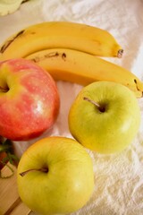 Ripe apples and bananas lie on a white tablecloth