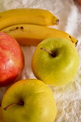 Ripe apples and bananas lie on a white tablecloth