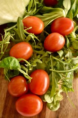 Fresh ripe cherry tomatoes and lettuce on a cutting board