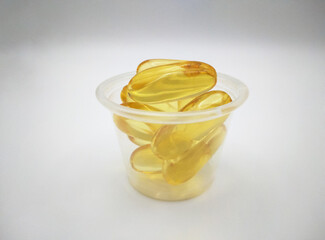 Food supplement oil filled gel capsules in plastic cup. Suitable for omega 3, omega 6, fish oil,...