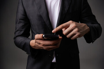 Businessman Extending Hand holding mobile phone in a Formal Suit.