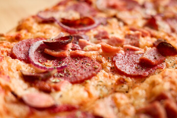 Freshly baked pizza is topped with savory pepperoni, sausage, and sliced onions, showcasing a crispy crust and melted cheese. Perfect for a casual meal at home